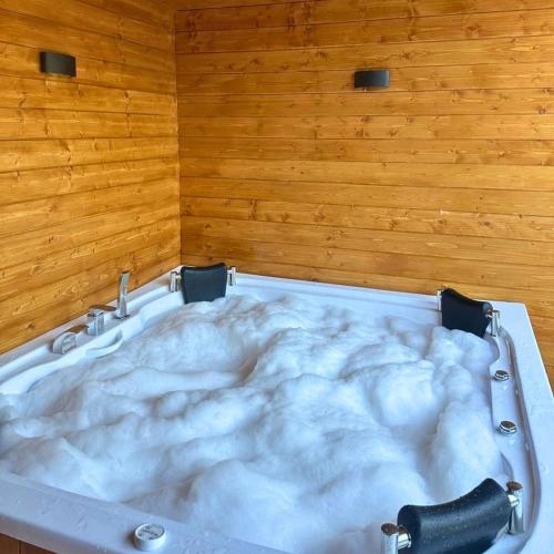 a bath tub in a room with a wooden wall at Uludag Zirve Garden - BBQ Jacuzzi 
