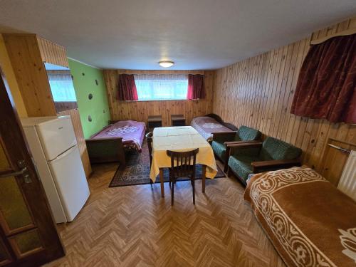a small room with a table and a couch and a refrigerator at Pas Povilą in Jurbarkas