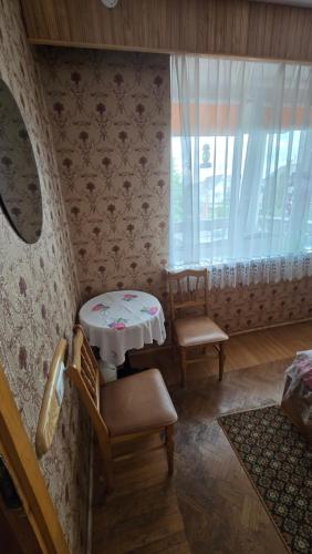 a room with a table and two chairs and a window at Pas Povilą in Jurbarkas