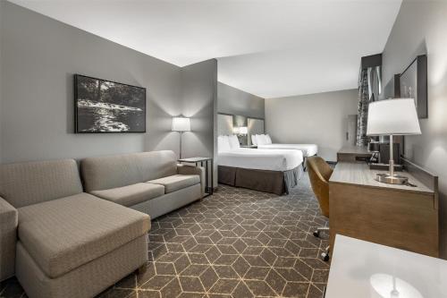 a hotel room with a couch and a bed at Best Western Plus Lawrenceburg in Lawrenceburg