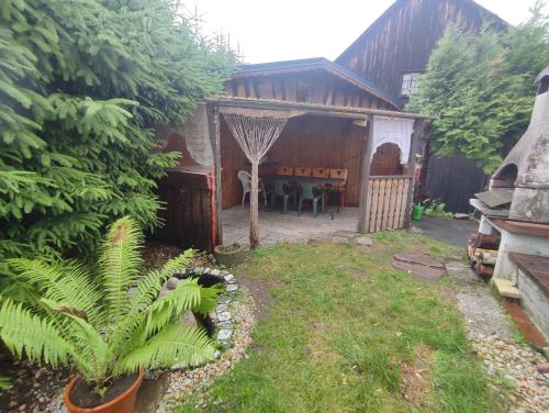 a backyard with a wooden house with a table at FerienHaus "Grimberg" & großes Grundstück in Schwarzenbrunn