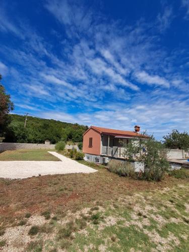 a house in a field with a sky at Olive Apartment Rovinj in Rovinj