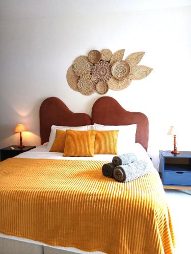 a bedroom with a yellow bed with two towels on it at Suíte Casal com Hidro no Centro - Infinito Particular in Guararema