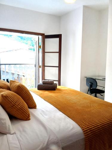 a bedroom with a large bed with a large window at Suíte Casal com Hidro no Centro - Infinito Particular in Guararema