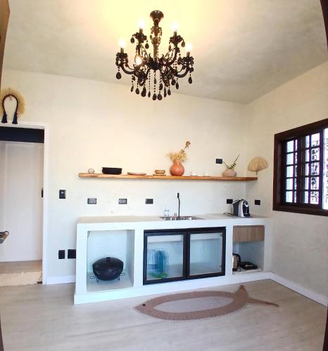 a living room with a sink and a chandelier at Suíte Casal com Hidro no Centro - Infinito Particular in Guararema