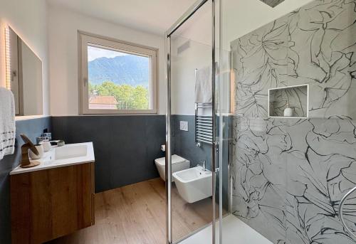 a bathroom with a shower and a sink and a toilet at Villa Lake Luxury in Colico