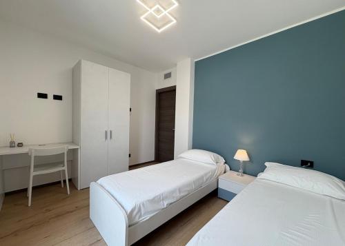 a bedroom with two beds and a desk in it at Villa Lake Luxury in Colico