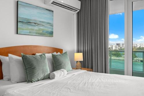 a bedroom with a bed with a large window at Condado Lagoon by Otium in San Juan