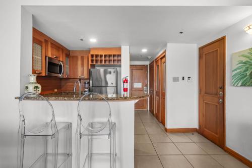 a kitchen with two bar stools at a counter at Condado Lagoon by Otium in San Juan