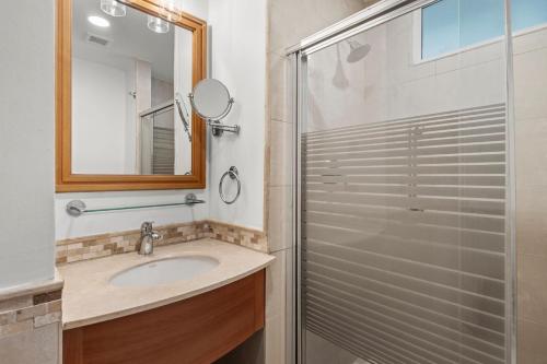 a bathroom with a shower and a sink and a mirror at Condado Lagoon by Otium in San Juan