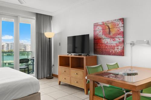 a hotel room with a bed and a desk and a television at Condado Lagoon by Otium in San Juan