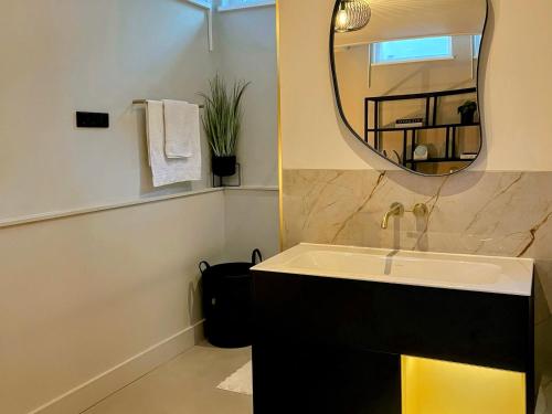 a bathroom with a sink and a mirror at B&B bij Germaine in Heeze