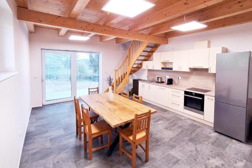 a kitchen with a wooden table and a refrigerator at Chalet Pasečná in Přední Výtoň