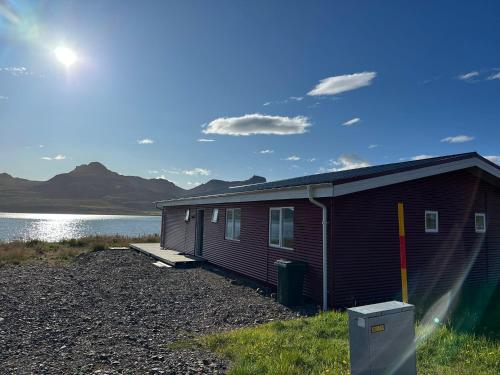 a small house next to a body of water at Álfheimar Hotel in Borgarfjordur Eystri