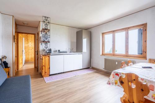 a kitchen and living room with a table and a kitchen at Appartamento Lulù Polsa in Brentonico