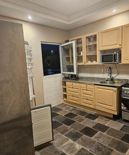 a kitchen with wooden cabinets and a tile floor at Appartement distelberg in Lomé