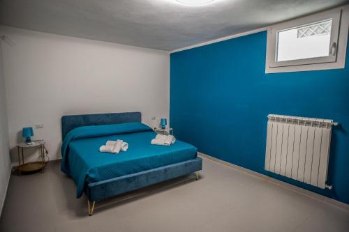 Un dormitorio azul con una cama con toallas. en Casa Maremonti, en Lido di Camaiore