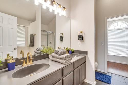 a bathroom with two sinks and a large mirror at 14 Mi to Dtwn OKC Edmond Gem with Fenced Yard! in Edmond