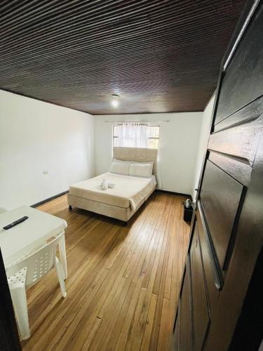 a bedroom with a bed and a desk in it at Hotel Colonial El Gran Fénix in Tunja
