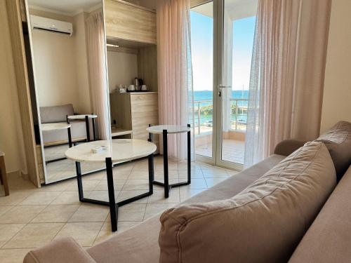 a living room with a couch and a view of the ocean at Bel Ami Suita Hotel in Vlorë