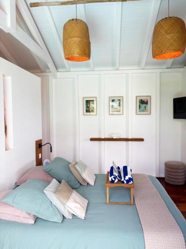 a bedroom with a bed with pillows and a table at ZANNANNA LODGE in Le Diamant