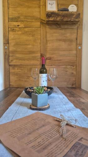 una bottiglia di vino e due bicchieri di vino su un tavolo di Casa LADIS a Iernut