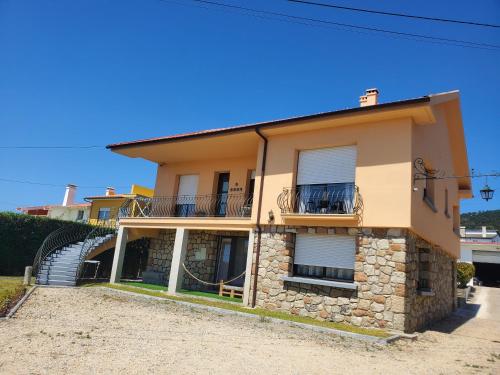 a large yellow house with a balcony at Villa Ribeiro in Vila Praia de Âncora