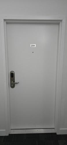a large white door with a door knob on it at New Royal Inn in New Westminster