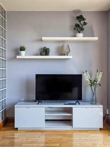 a white entertainment center with a tv in a living room at Beachside - Stunning sea view townhouse across the road from the beach in Kilkeel