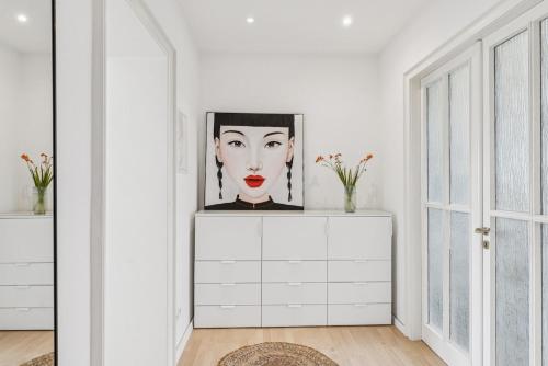 a white room with a portrait of a woman on a dresser at Altbaujuwel in Schwelm, nahe Köln,DO,Df 4 Pers in Schwelm
