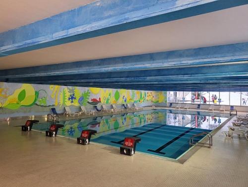 a swimming pool in a gymnasium with a swimming pool at Genziana Apartment in Marilleva
