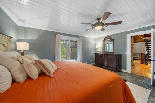 a bedroom with an orange bed with a ceiling fan at Lake Hills Hideaway in Wilkesboro