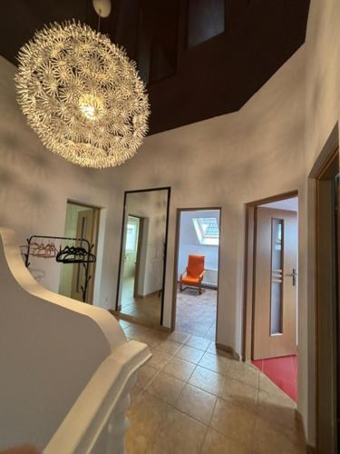 a room with a chandelier and a hallway with a chair at Bliźniak Swornegacie in Swornegacie 