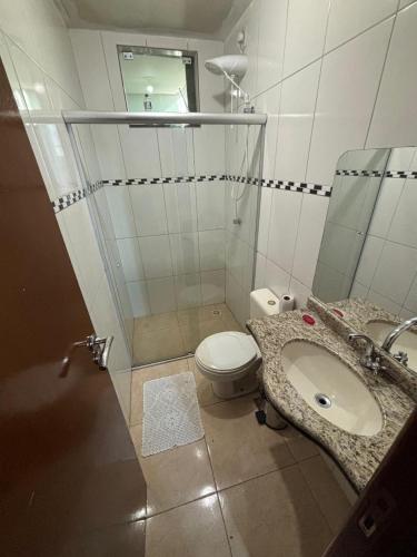 Un baño con inodoro, lavabo y ducha. en Suíte confortável e espaçosa, en Goiânia