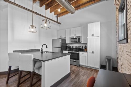 an open kitchen with white cabinets and a counter top at Brick & Bed Riverfront Lofts, PC 101 in Saint Louis