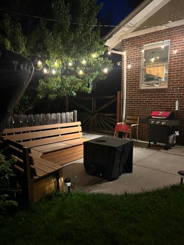 a wooden bench with a tv in the yard at night at Quiet, Immaculate Denver Home Relax or Work Near Dining & Attractions! in Denver