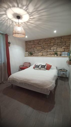 a bedroom with a bed and a stone wall at La Tourelle - Gite et chambre d'hôte in Saint-Antonin