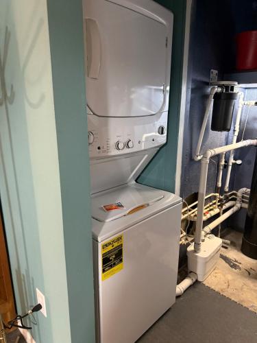 a white refrigerator with a microwave on top of it at Cozy Retreat in the Heart of it all! in Brooksville