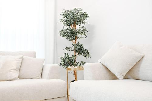 a living room with two white couches and trees at Spacious 2BR in Ansam Yas Island Views Sleeps 7 in Abu Dhabi