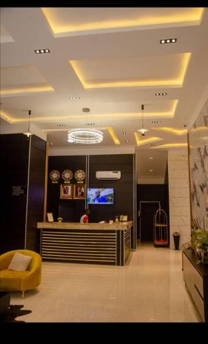 a lobby with a yellow chair and a television at villa Toscana GRA Port Harcourt in Port Harcourt