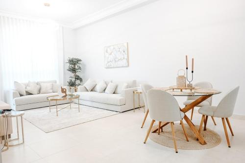a living room with white furniture and a table at Spacious 2BR in Ansam Yas Island Views Sleeps 7 in Abu Dhabi