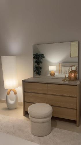 a bathroom with a dresser with a toilet and two lamps at Spacious 2BR in Ansam Yas Island Views Sleeps 7 in Abu Dhabi