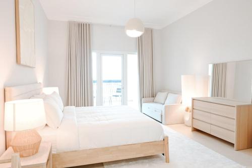 a white bedroom with a bed and a couch at Spacious 2BR in Ansam Yas Island Views Sleeps 7 in Abu Dhabi