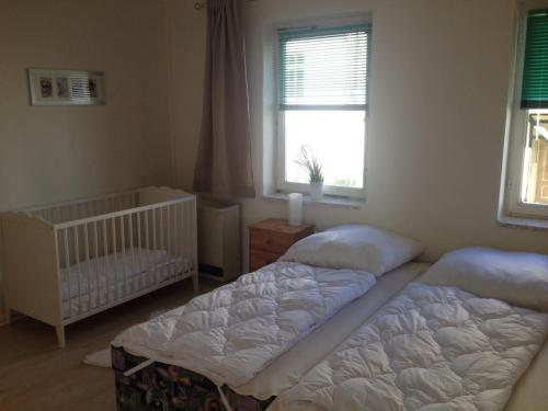 two beds in a room with a crib and a window at Ferienwohnung Odessa in Zinnowitz