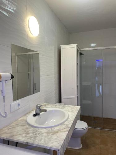 a bathroom with a sink and a toilet at Villa LiLo Private House with Heated Pool in Costa Teguise