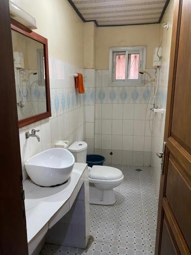 a bathroom with a sink and a toilet at Résidence H - Ekoumdoum in Yaoundé