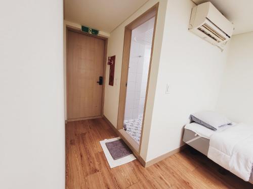 a bedroom with a mirror and a bed and a shower at BK Room in Incheon