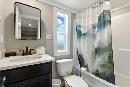 a bathroom with a sink and a toilet and a window at Pigeon Forge Landing RV Resort in Pigeon Forge