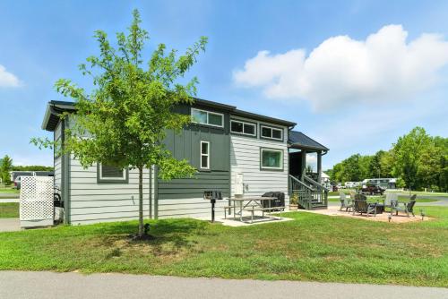 a small house with a tree in the yard at Pigeon Forge Landing RV Resort in Pigeon Forge