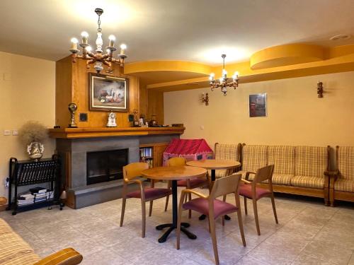 a living room with a table and chairs and a fireplace at Apartamentos Lausan in Gavín